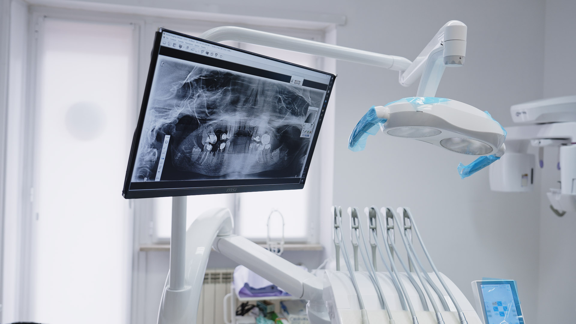 Dentista e assistente sorridenti con paziente adulto nello studio dentistico moderno